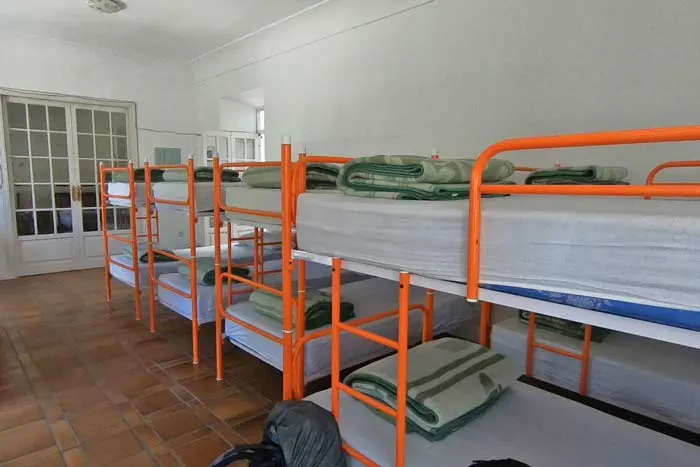 A dormitory with many metal bunk beds next to each other