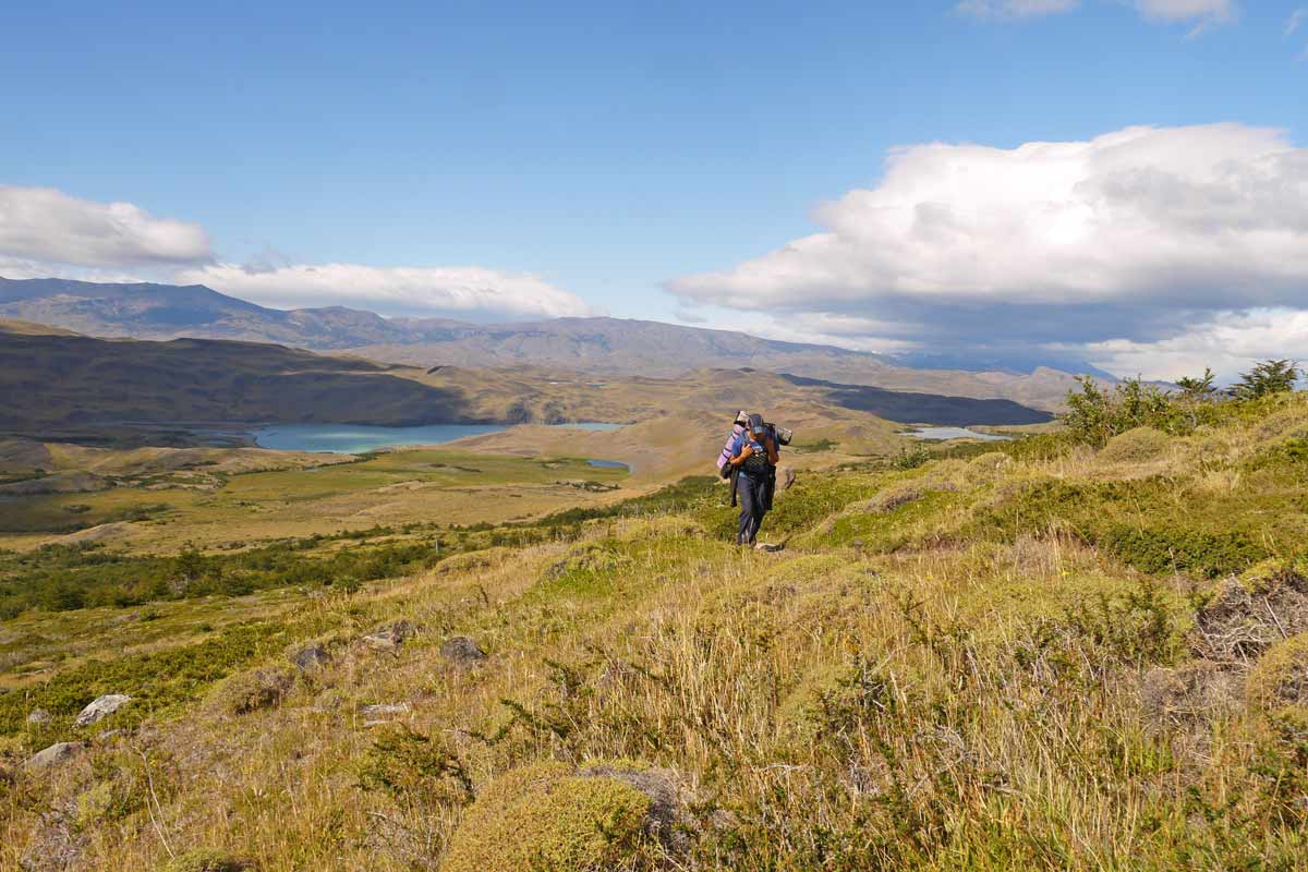 Campbell on a hiking trail in Patagonia carrying all his camping gear