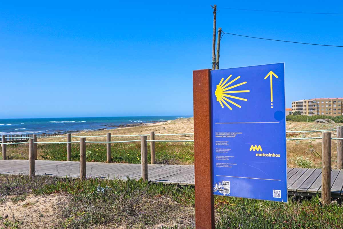 A big blue sign with a yellow shell and arrow indicating the Camino de Santiago route