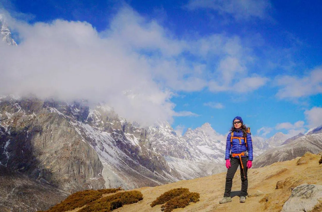 lady in trekking gear backpacking in the mountains