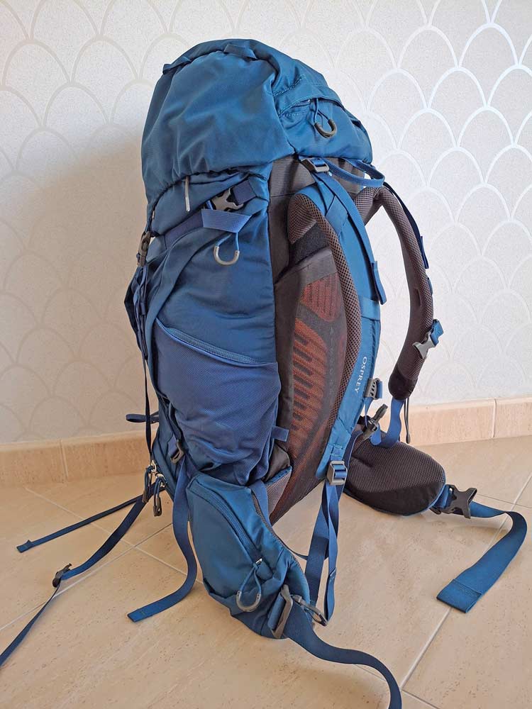 blue packpack standing against a wall