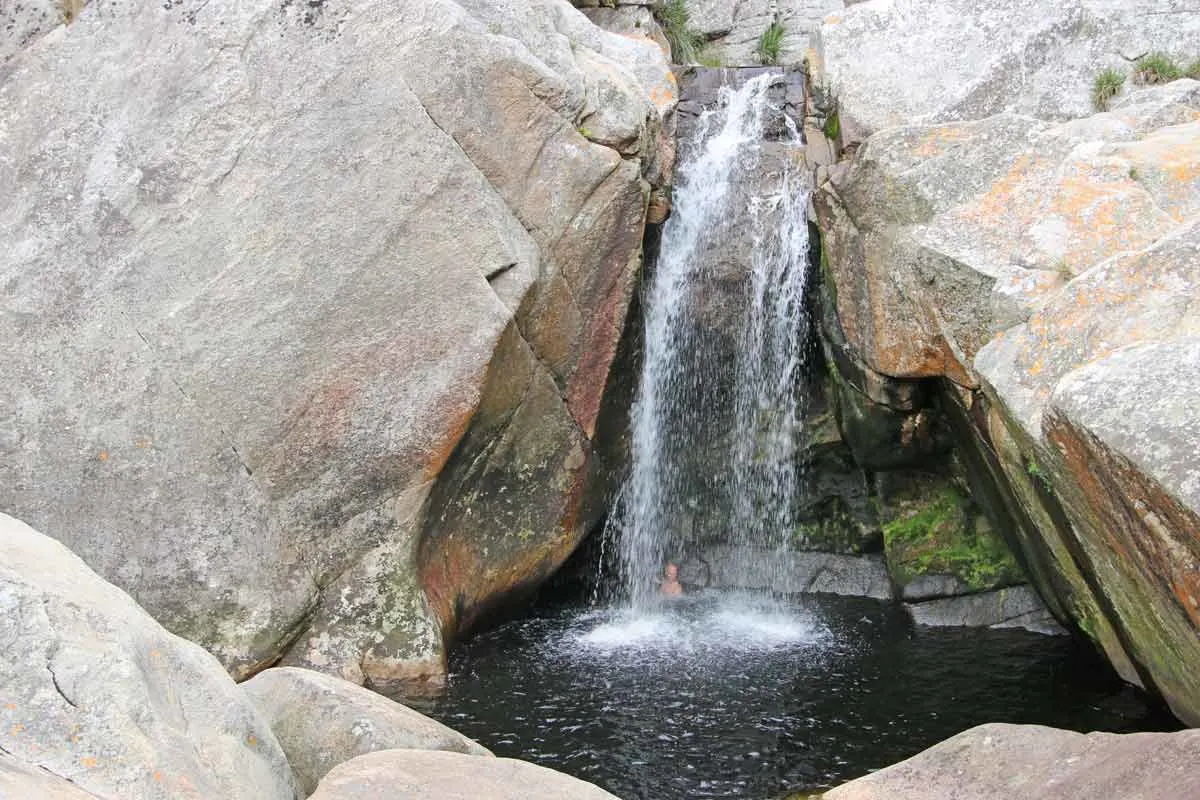 Campbell swimming under the waterfall on the Kingfisher Trail at Ebb and Flow