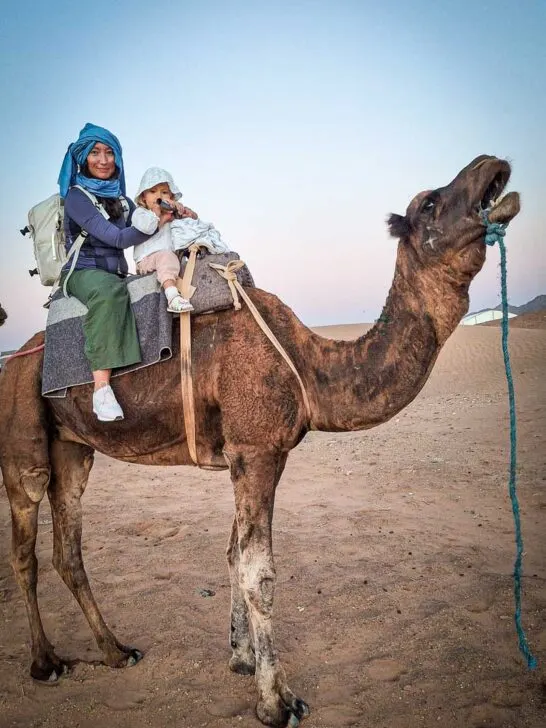 mom and daughter on camel in the desert