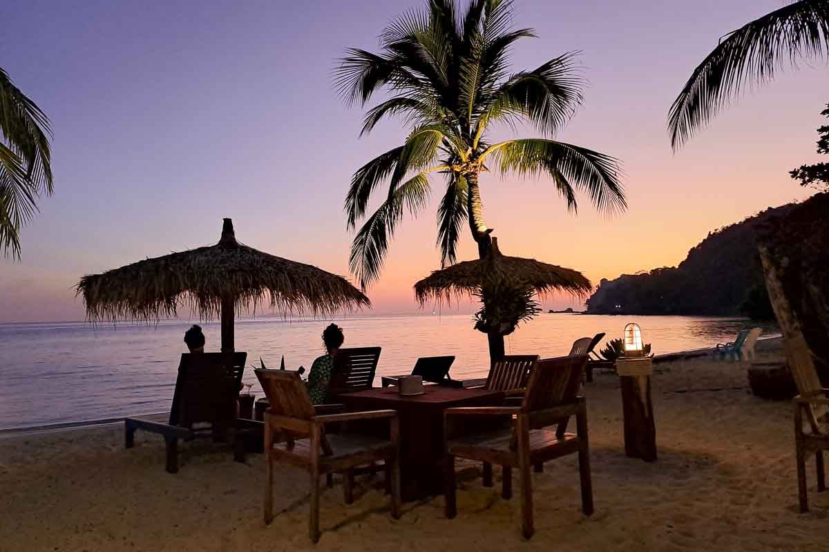 sunset with tables on the beach on perfect island