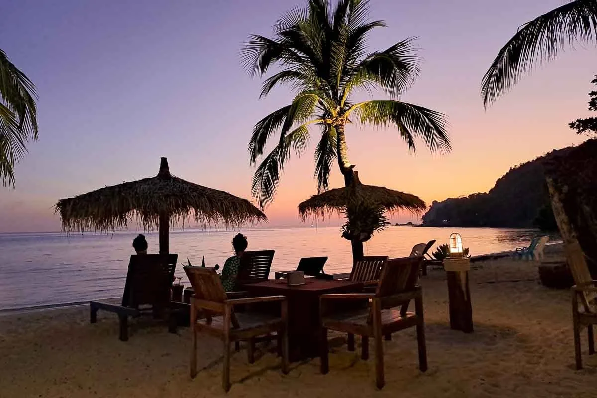 sunset with tables on the  beach on perfect island