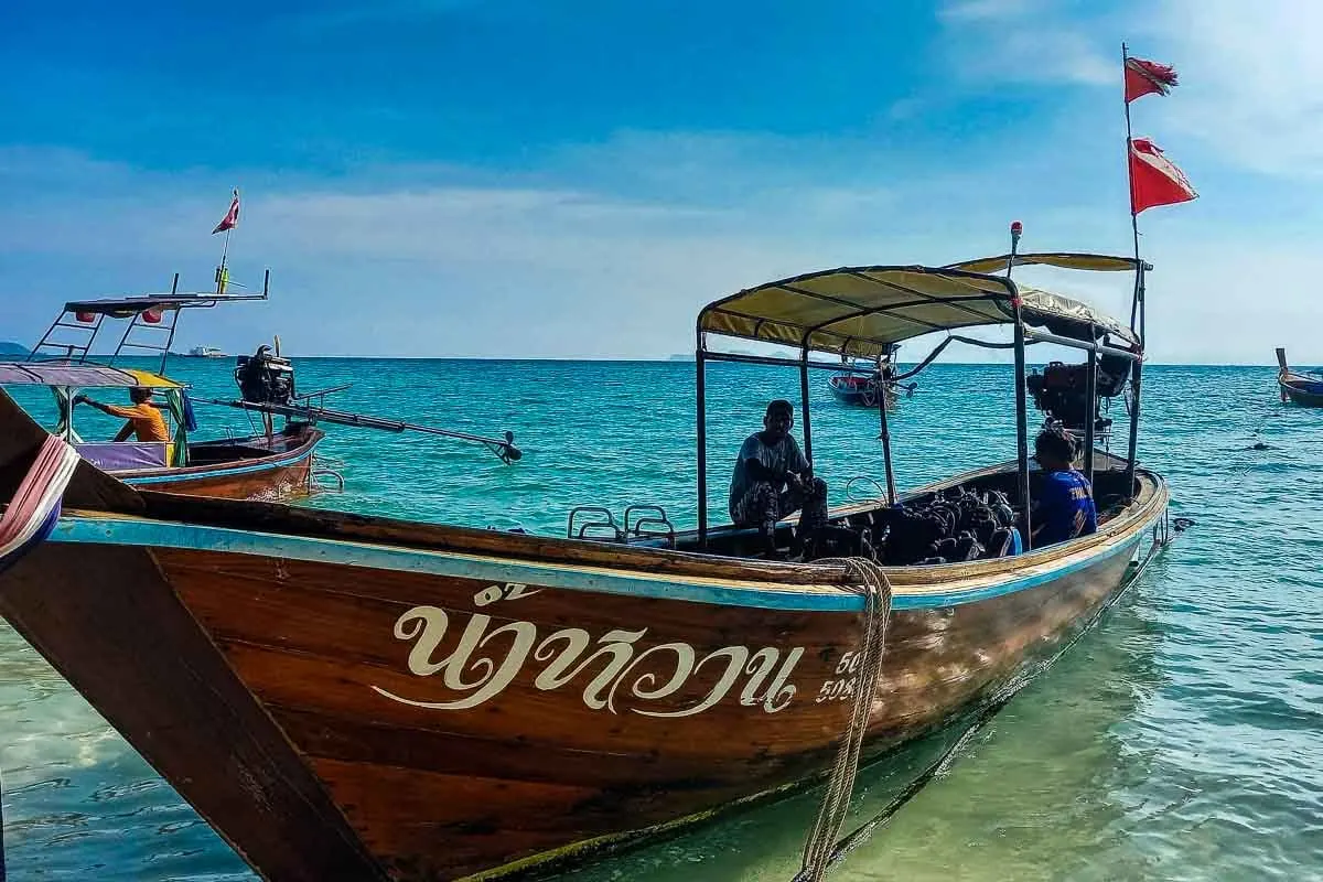 long tail wooden boat blue water thailand