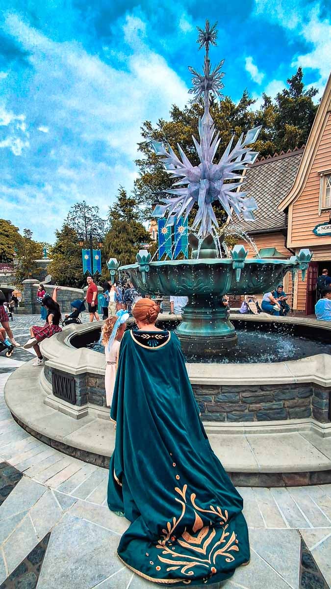 little girl talking to Anna from Frozen at water fountain