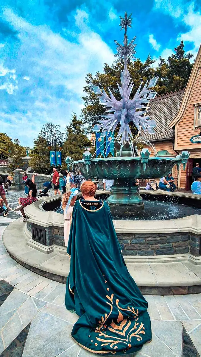 little girl talking to Anna from Frozen at water fountain