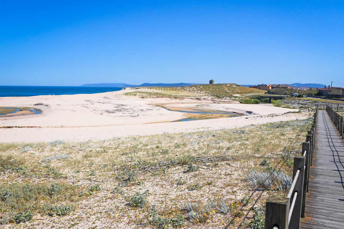 A wide sandy beach with a boardwalk south of Vila do Conde