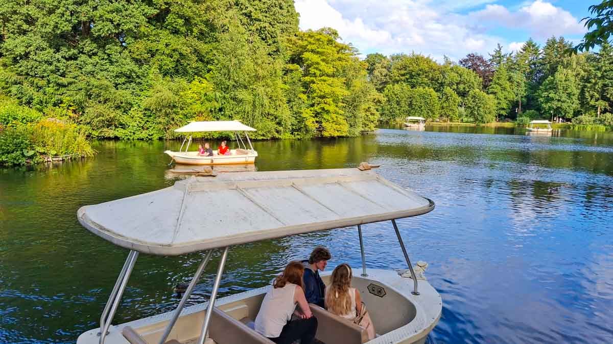 boats on a river with lots of trees on the banks