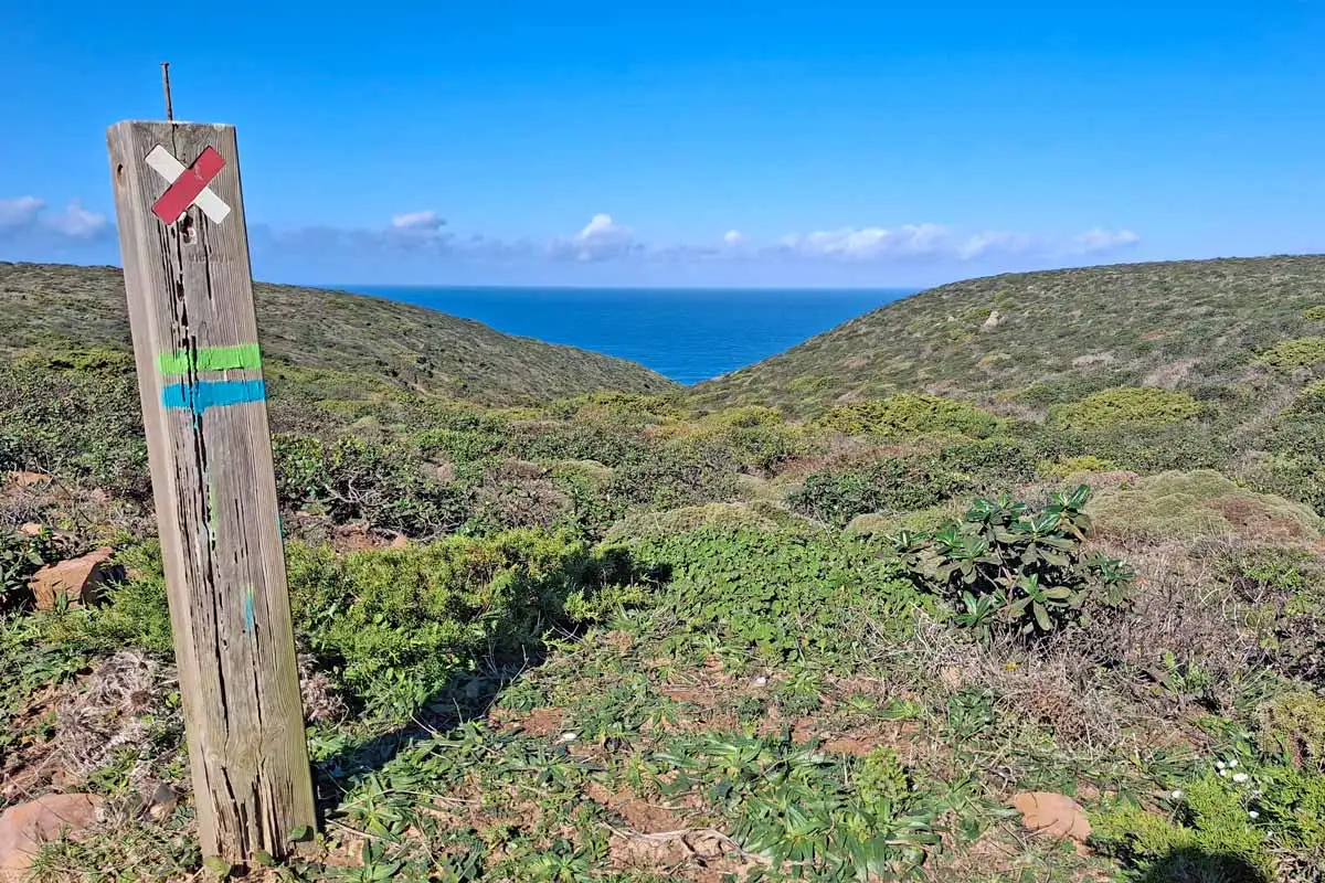 pole with a red and white cross and blue and green stripes