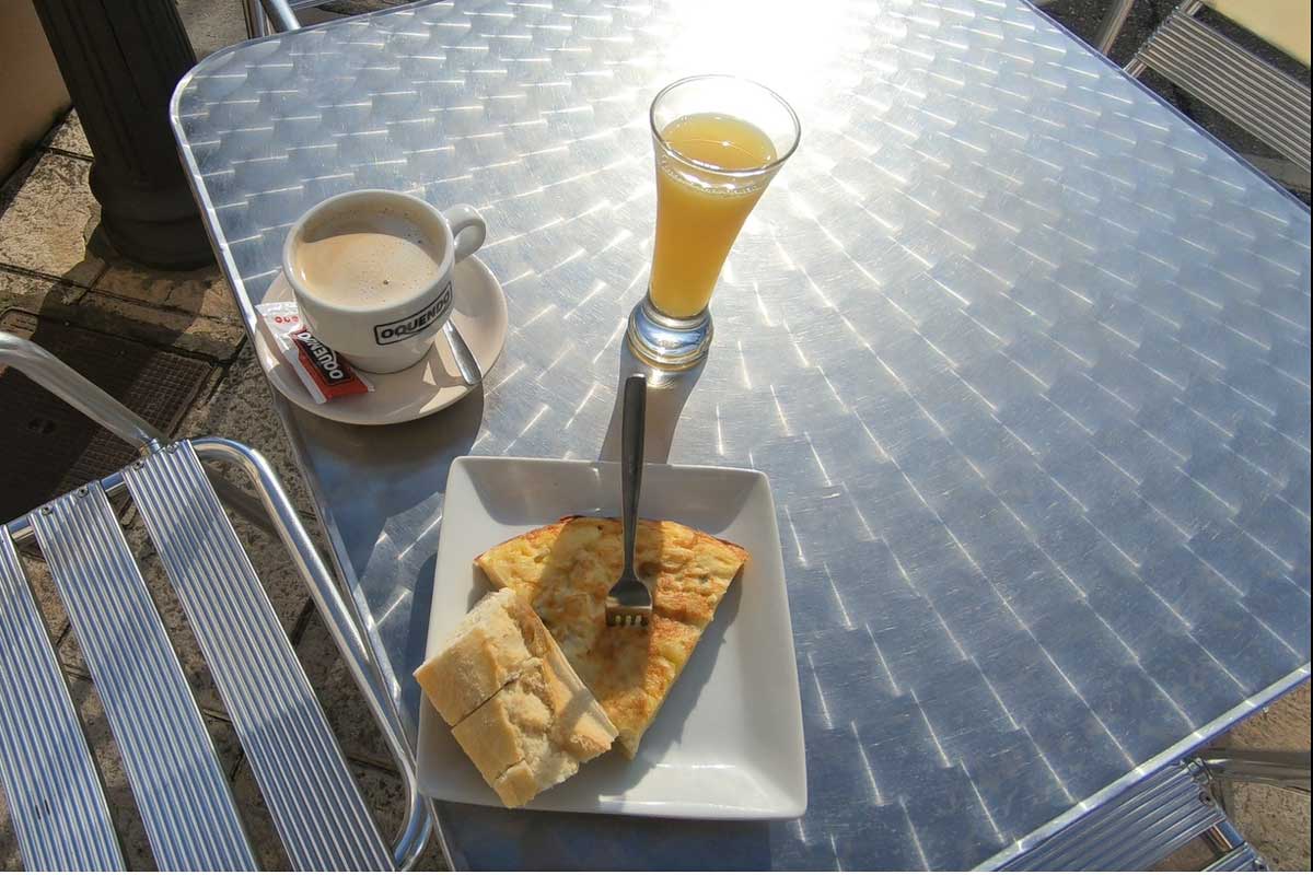 A typical breakfast with coffee, orange juice, and tortilla on the French Camino
